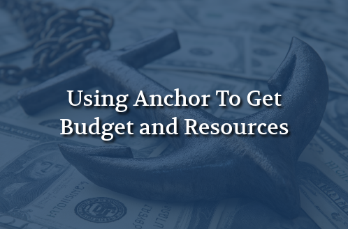 A large anchor rests on scattered dollar bills in the background. The text reads "Using Anchor To Get Budget and Resources," suggesting financial strategy.