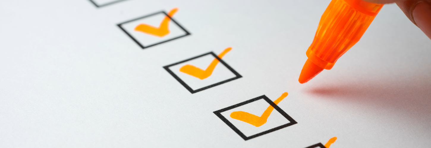 Close-up image of a checklist with multiple checked boxes marked in orange, alongside an orange marker pen, symbolizing risk assessments, compliance reviews, and evaluation processes.