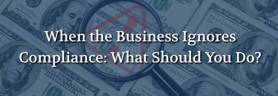 Magnifying glass highlighting a warning symbol over U.S. currency, representing business compliance risks and financial consequences.